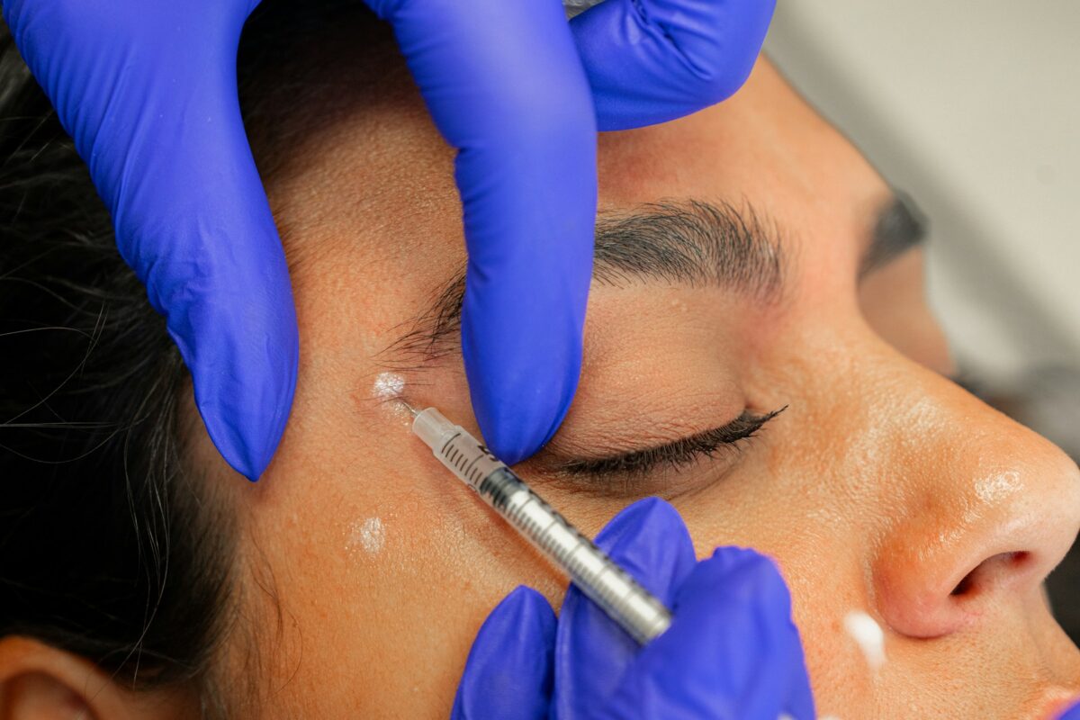 Provider administering Botox in Oklahoma to smooth forehead and crow's feet wrinkles during a cosmetic treatment.