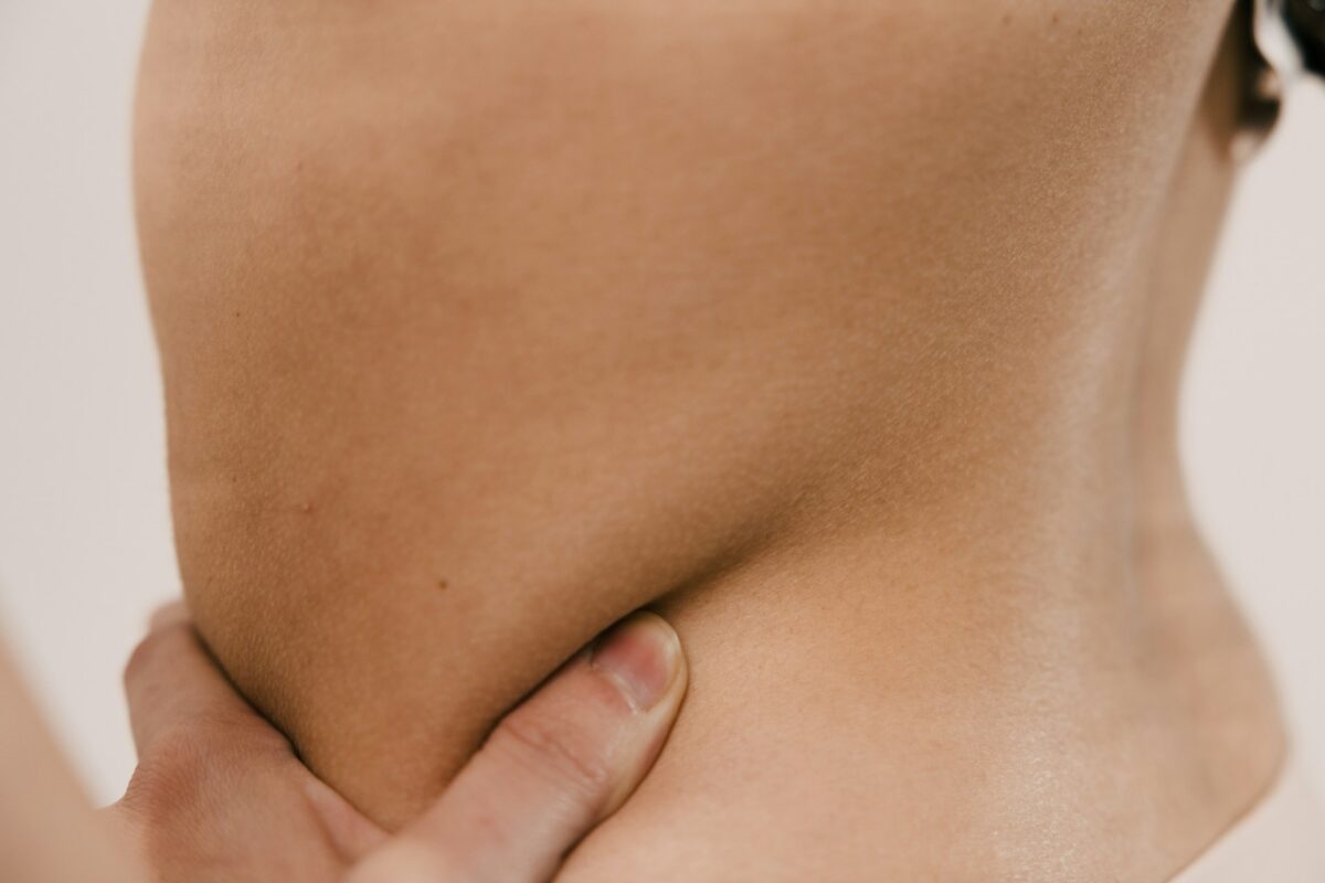 Close-up of abdomen during a non-surgical body contouring consultation for reducing stubborn fat.