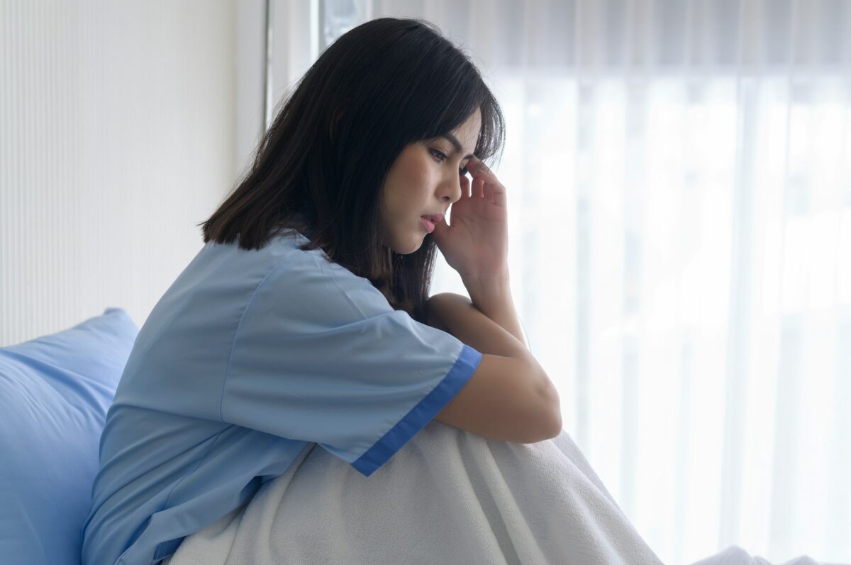 Woman recovering after tummy tuck surgery concerned about healing and recognizing signs of complications during recovery.