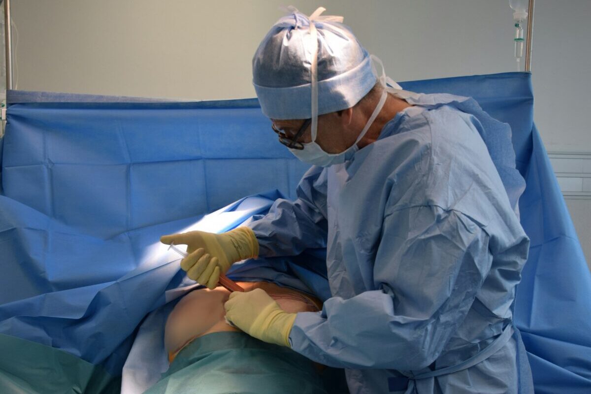 Plastic surgeon performing breast augmentation revision surgery to improve cosmetic results and correct implant concerns.