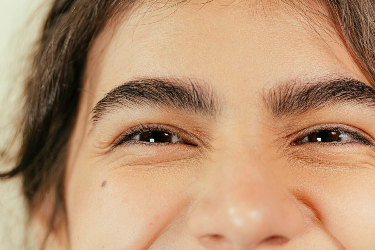 Close-up of a smiling woman with naturally lifted brows after Dysport treatment for subtle facial rejuvenation.
