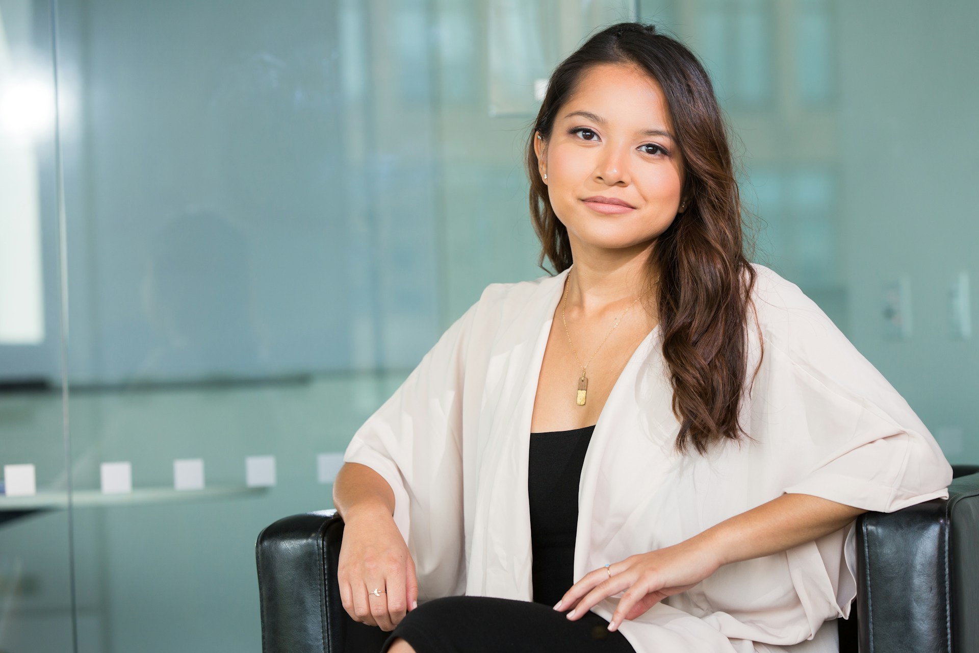 Woman sitting calmly in a consultation setting while considering breast reconstruction after mastectomy.