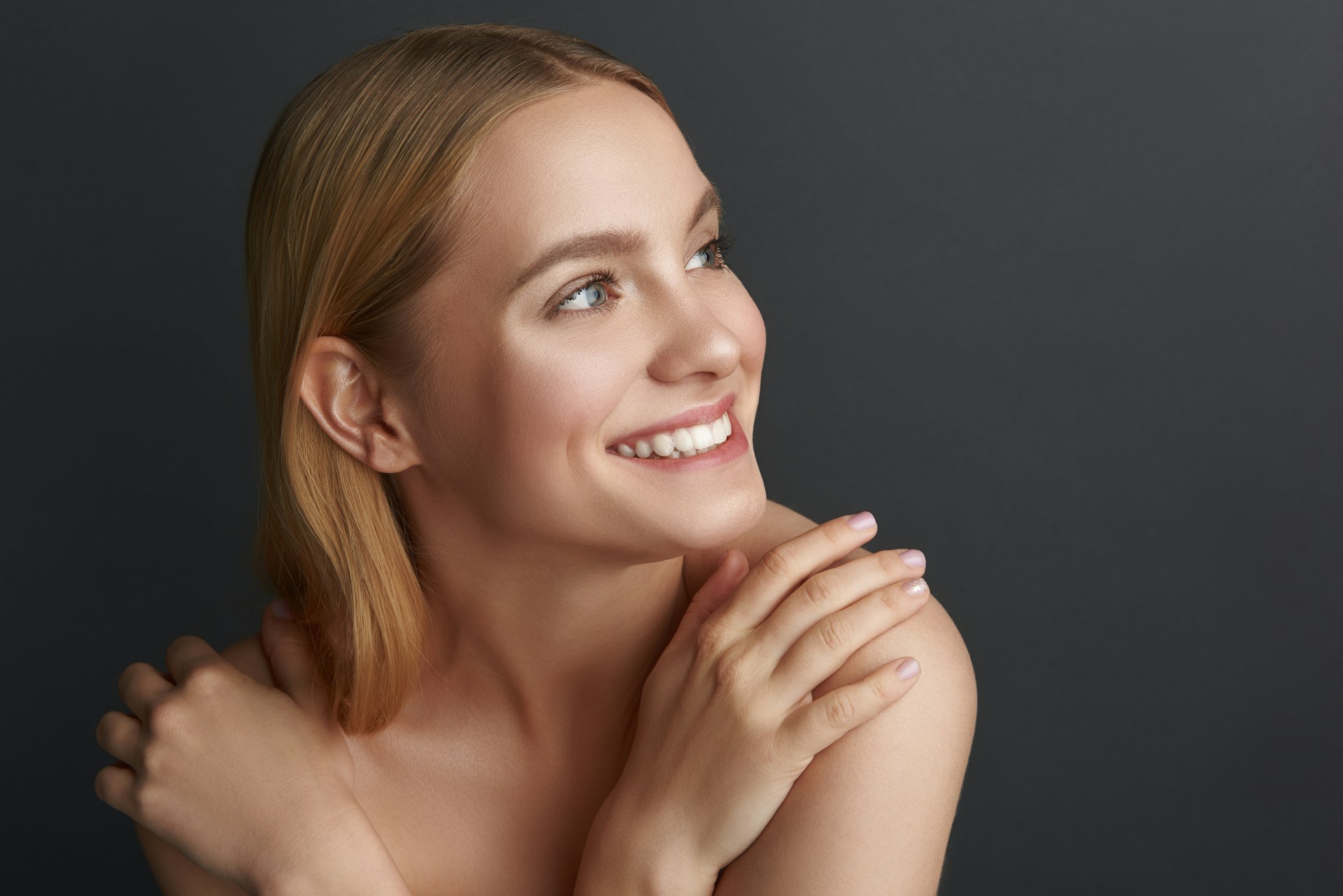Woman smiling with smooth, refreshed skin representing natural results from non-surgical facial rejuvenation.