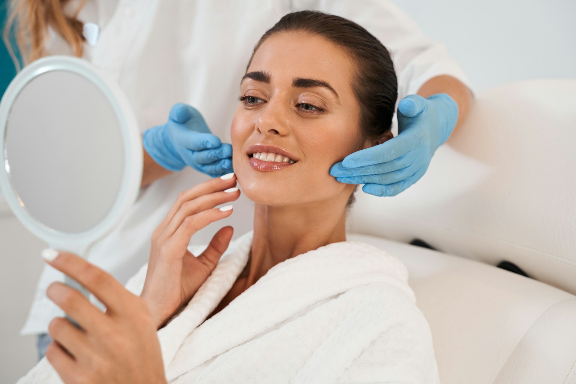 Woman reviewing her facial contour after PDO threads treatment with a skincare professional.