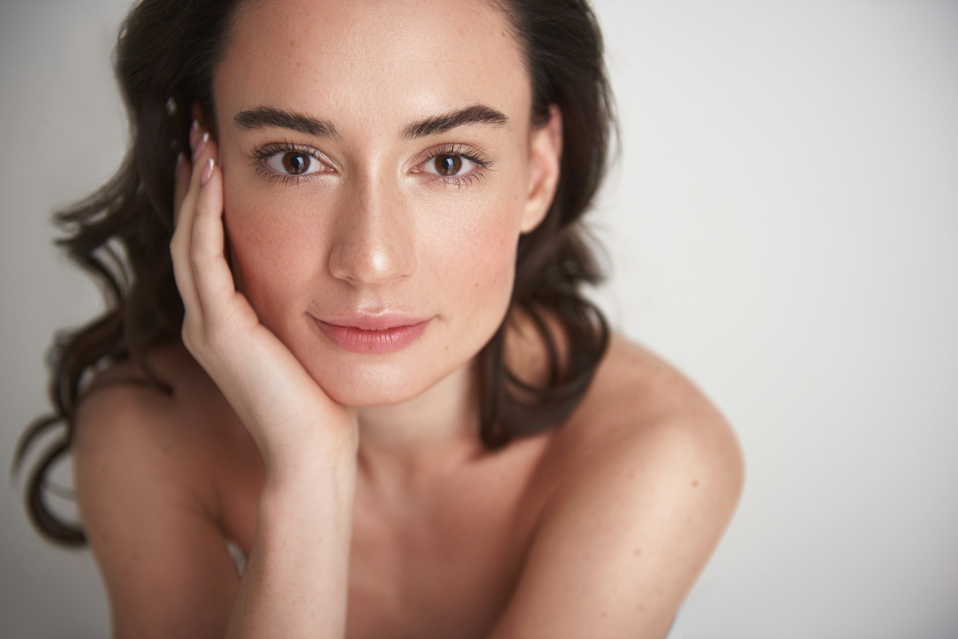 Woman with a natural-looking complexion representing confidence and facial rejuvenation through cosmetic surgery.