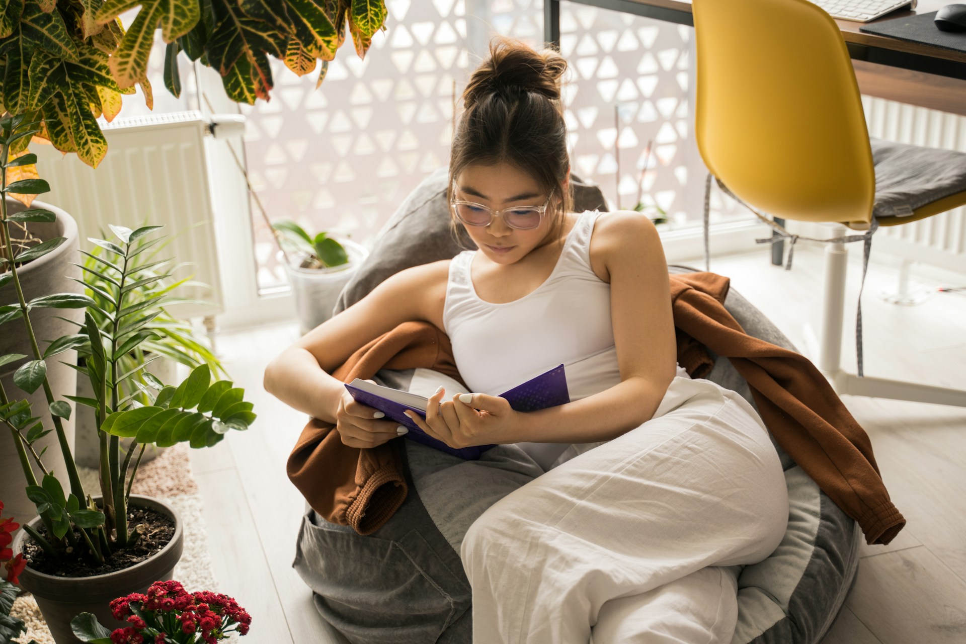Woman resting at home while reading during breast augmentation surgery recovery.