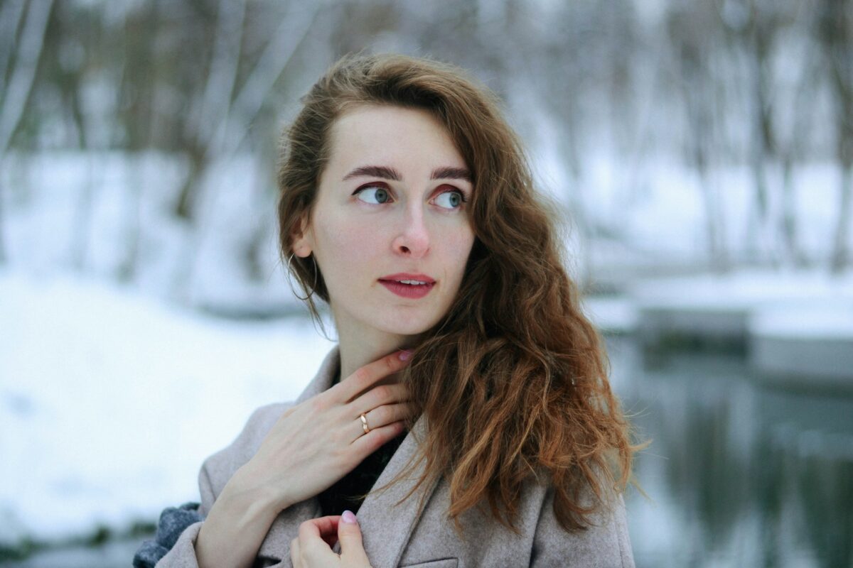 Woman outdoors in winter weather protecting her skin with a healthy winter skin care routine.